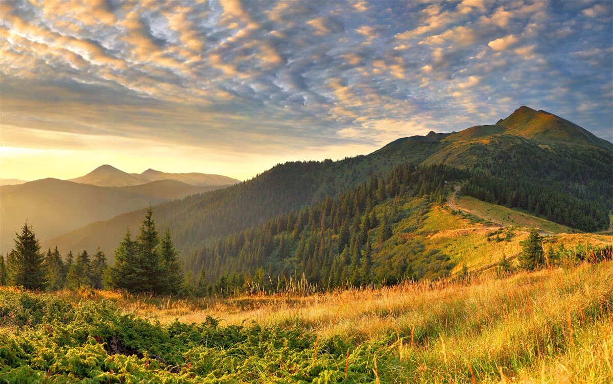 Фотошпалери хмари над горами забарвлені в теплі кольори заходу сонця
