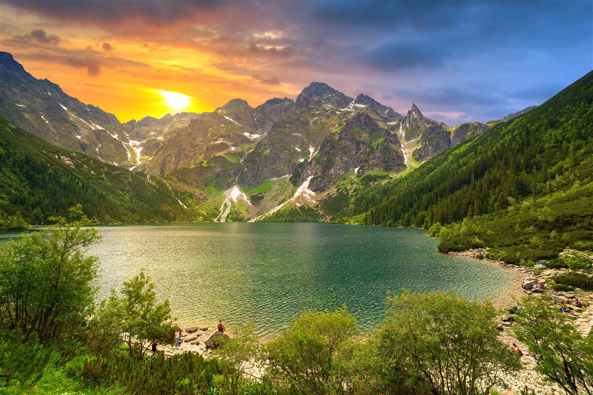 Фотошпалери вражаючий захід сонця за гірськими хребтами біля озера
