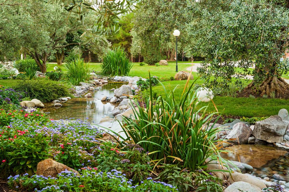 Фотошпалери струмок, що тече зеленим лугом