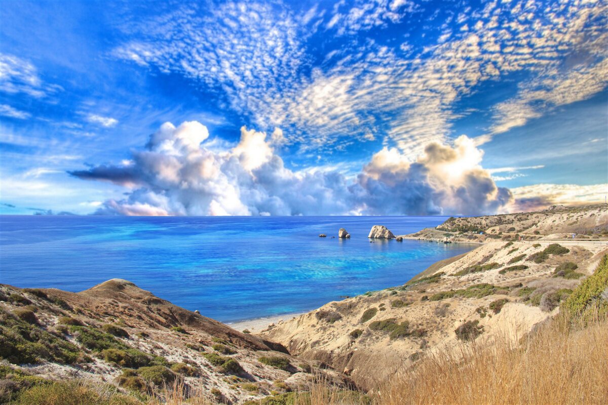 Фотошпалери перисті хмари на горизонті на межі між сушею та океаном